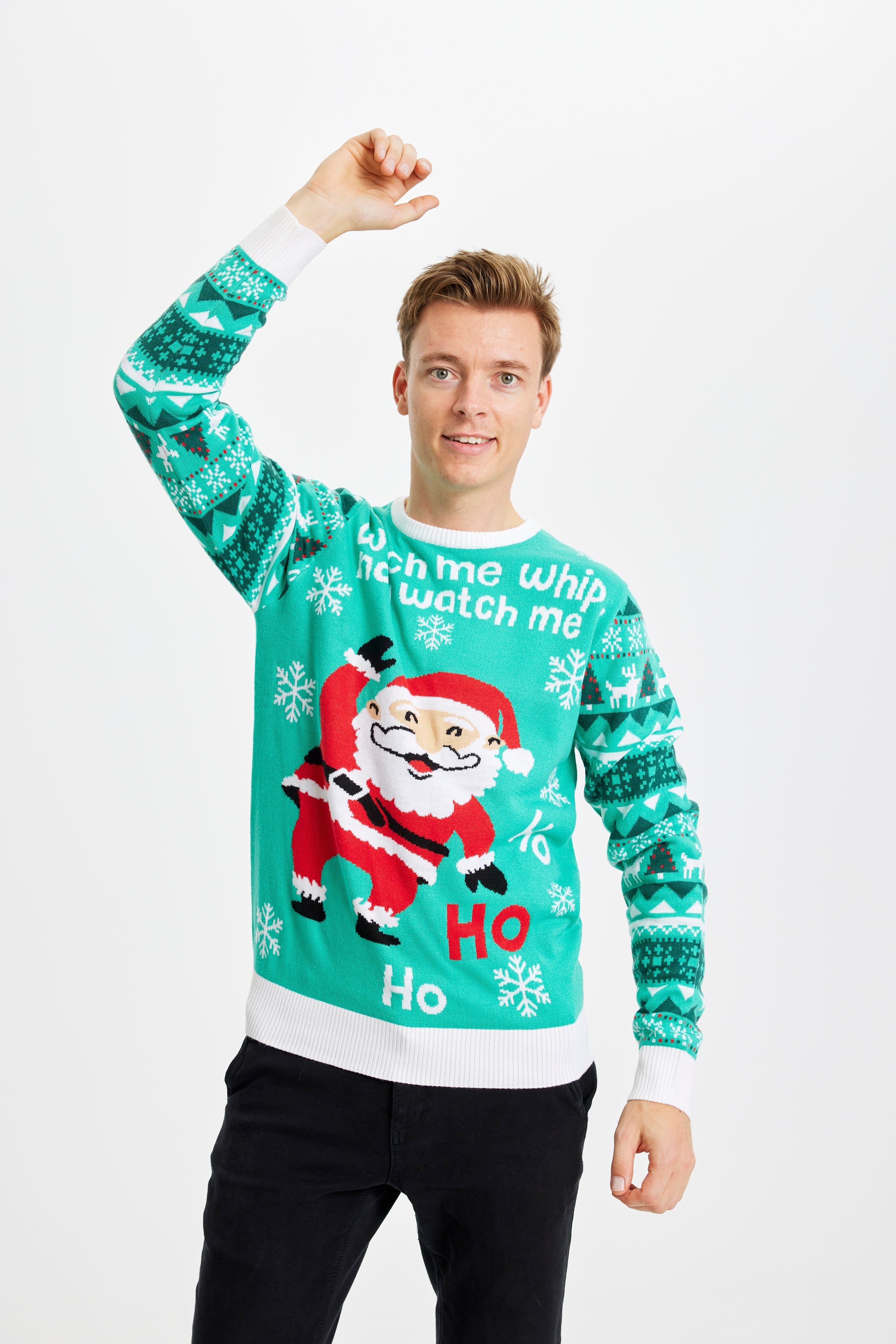 Ein tanzender Mann trägt einen türkisfarbenen Weihnachtspulli mit dem Spruch